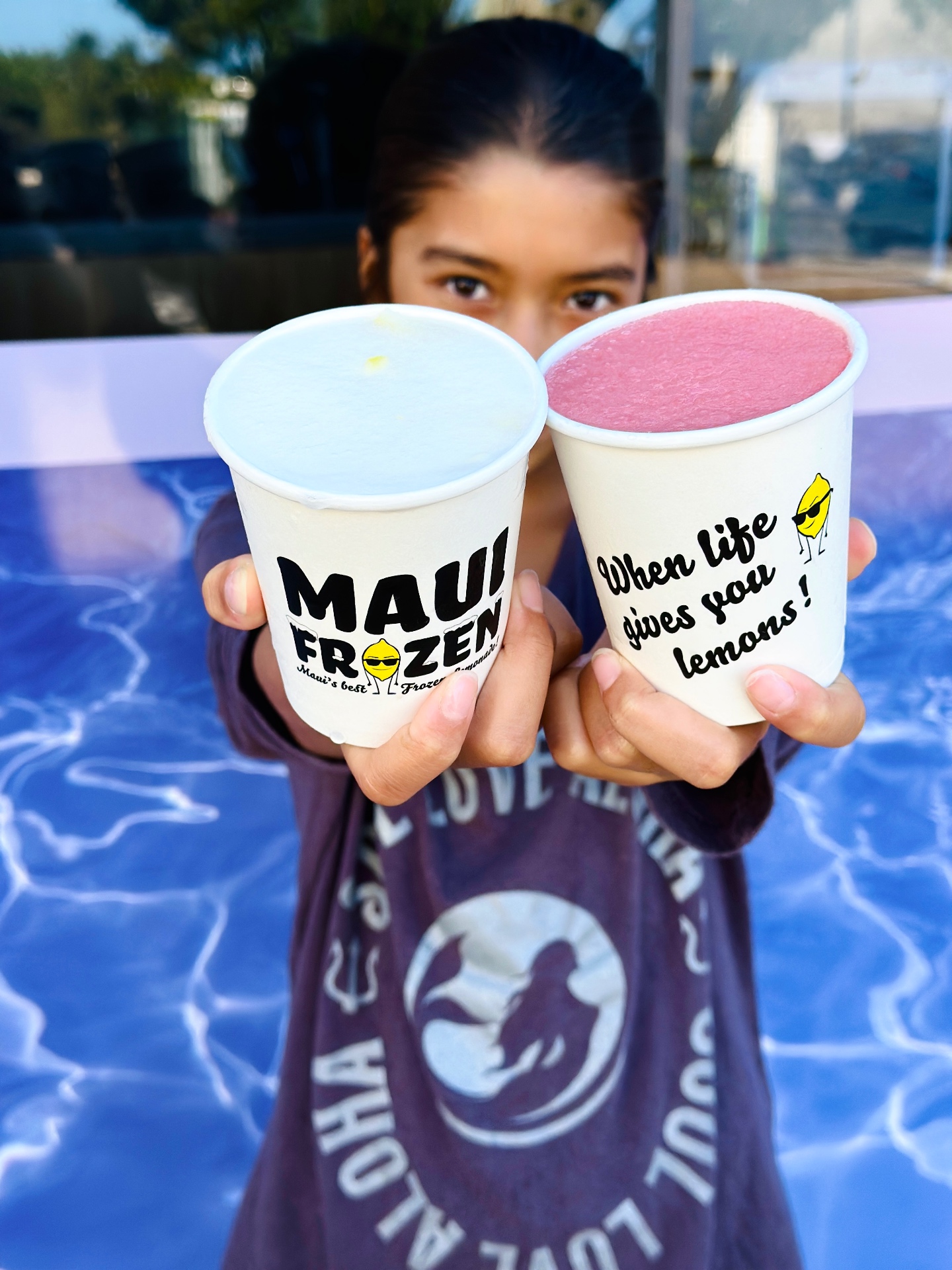 Friends holding Maui Frozen cups at a community event on Maui